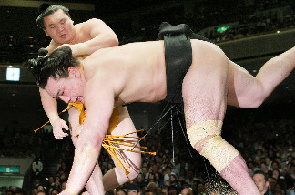Mongolian-born grand champion, or yokozuna, Hakuho (top) throws his compatriot Harumafuji on the final day of the 15-day Summer Grand Sumo Tournament in Tokyo on May 23, 2010.