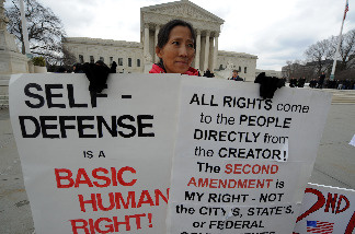 A demonstrator displays placards supporting a case on bearing arms in front of the Supreme Court in Washington, DC, on March 2, 2010.