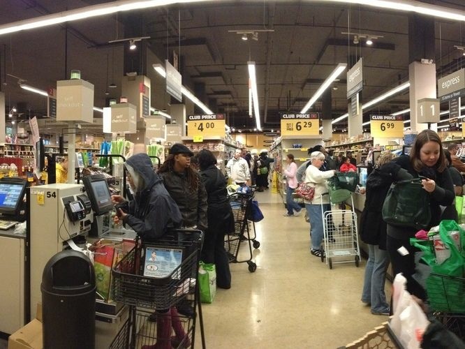 People wait to purchase groceries in self-checkout lanes at Safeway in Washington, D.C.
