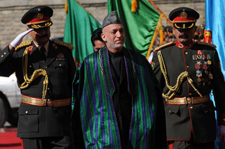 Afghan President Hamid Karzai (C) passes an honour guard as he arrives for his swearing in ceremony as the country's president for another five years at the Presidential Palace in Kabul on November 19, 2009.