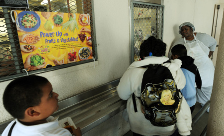 A cafeteria worker supervises lunches fo