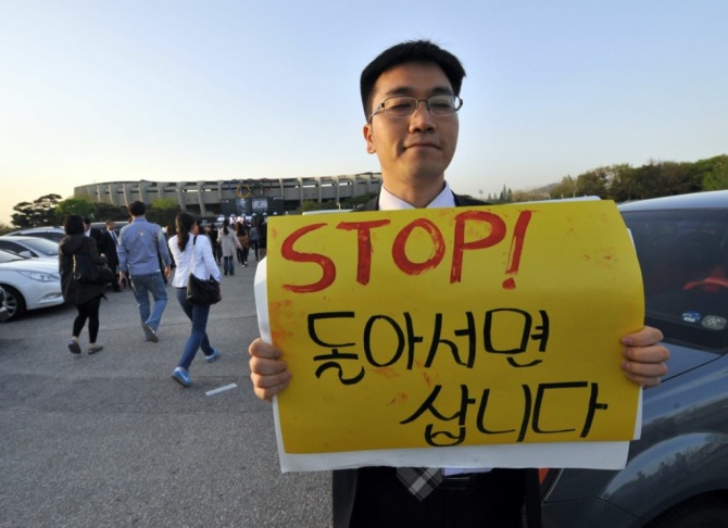 A protestors holds a placard against Lad