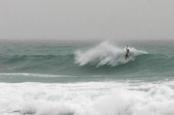 A tourist surfs the waves in Cabo San Lucas, Baja California, Mexico.