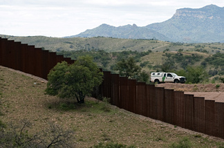 A US Border Patrol vehicle drives along the fence separating the US from Mexico, near the town of Nogales, Sonora, Mexico, on July 31, 2010.
