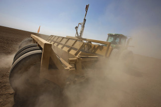 Farmers use tractors with laser surveying gear towed behind as they map out a new field on a farm in Imperial Valley, California, 12 August 2009.