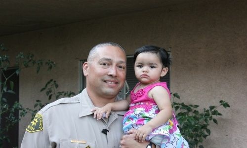 Deputy Joe Chavez with the 15-month-old La Puente girl whose life he saved at Bonelli Park on May 27, 2012.