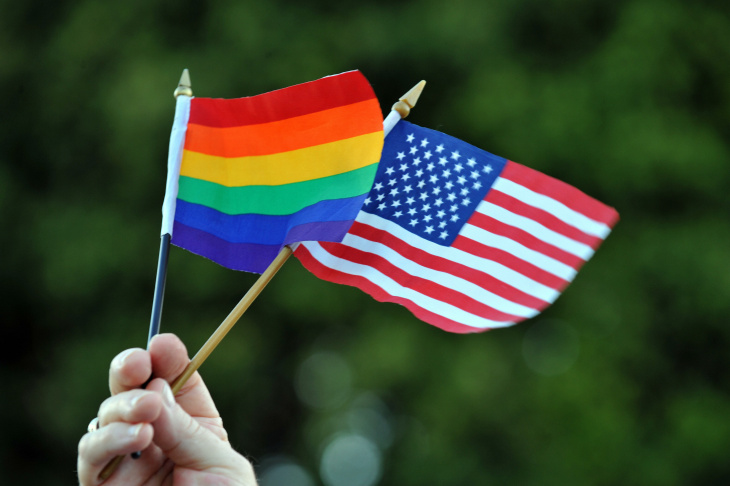 A gay man holds the gay and lesbian flag