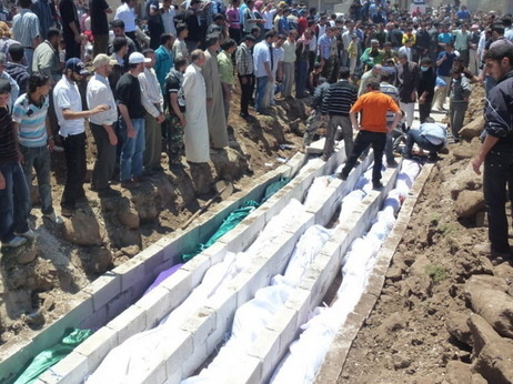 May 26, 2012: In this picture provided by the Syrian opposition's Shaam News Network, people watch the mass burial of victims in Houla.