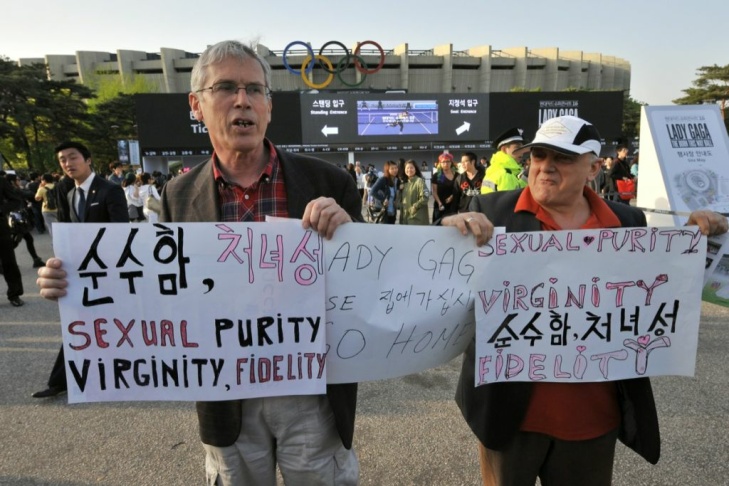 Protestors hold placards against Lady Ga
