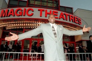 Former Los Angeles Lakers player Earvin 'Magic' Johnson stands in front of the 12-screen movie theatre that he built and financed during the theatre's grand opening.