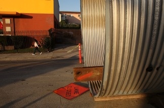 A pedestrian passes a city sewer project February 18, 2009 in Los Angeles, California.