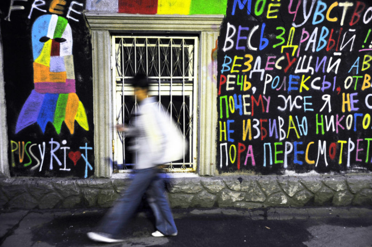 A man walks past a grafitti in support o