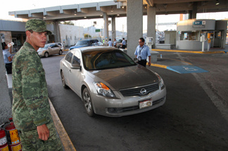 A Mexican soldier controls traffic at the Mexico-U.S. border customs post in Ciudad Juarez. Over the years, many undocumented immigrants from Mexico have been stuck in Juarez long-term after traveling there from the U.S. to apply for permission to return legally.