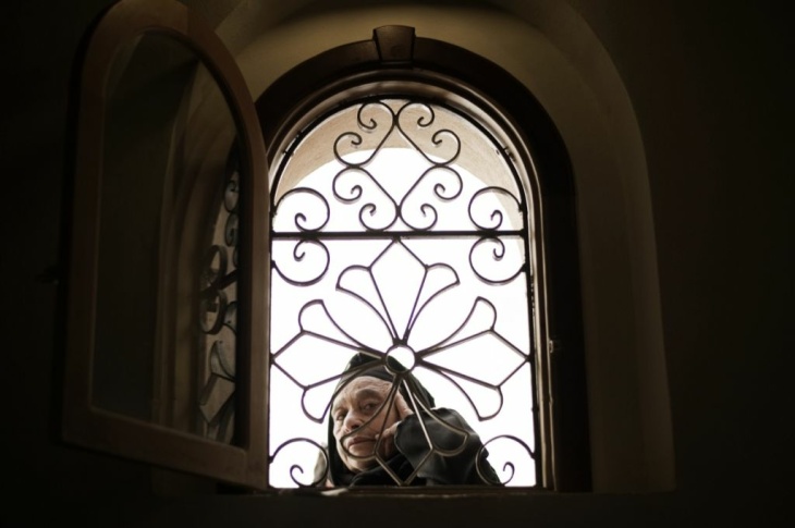 An Egyptian woman looks through a window