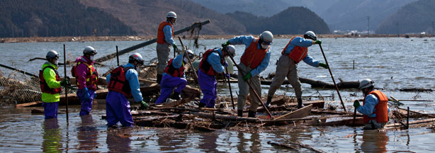 Japanese firemen pick through the rubble looking for bodies of victims of the tsunami in a flooded area of Ishinomaki in Miyagi prefecture on April 1, 2011.