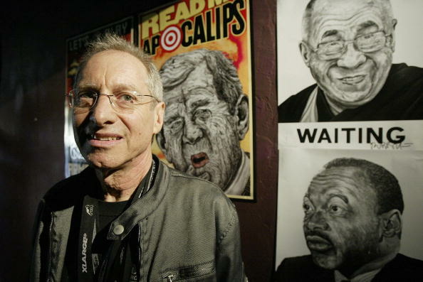 Artist Robbie Conal poses in front of so