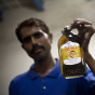 Pakistani worker Ansar poses with a bott