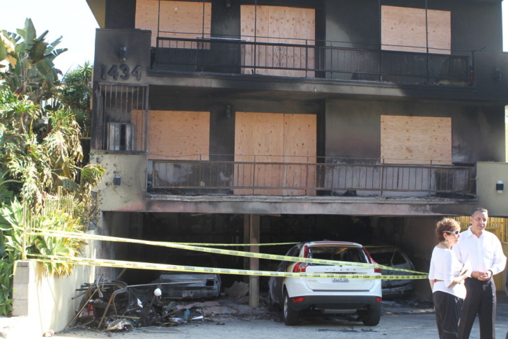 Boarded up windows, scorched facade 