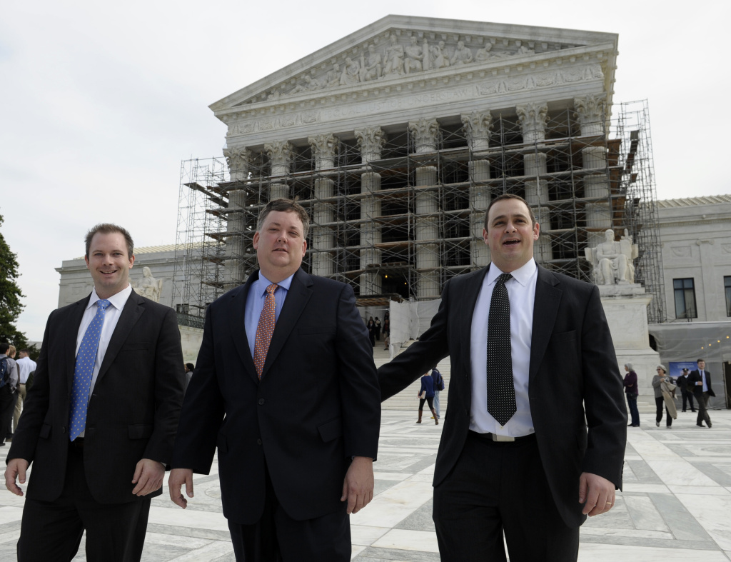 Republican activist Shaun McCutcheon of Hoover, Ala., center, leaves the Supreme Court in Washington, Tuesday, Oct. 8, 2013, after the court's hearing on campaign finance. The Supreme Court lifted limits on contributions by the biggest individual donors to political campaigns on April 2, 2014. McCutcheon, the national Republican Party and Senate Minority Leader Mitch McConnell of Ky. wanted the court to overturn the overall limits on what contributors may give in a two-year federal election cycle.