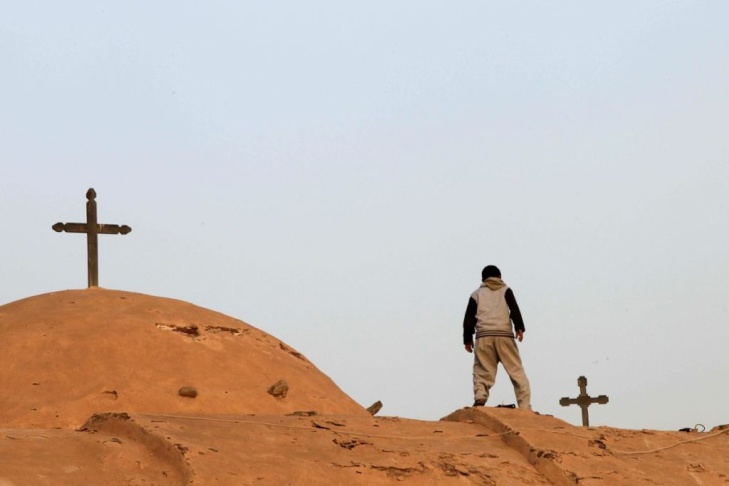 An Egyptian Coptic boy looks down from t