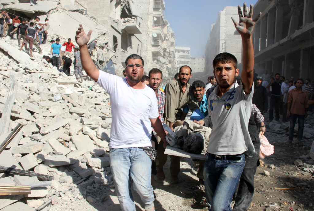 SYRIA-CONFLICT Syrian men evacuate a victim following an air strike by regime forces in the northern city of Aleppo on August 26, 2013. Syria's opposition accused pro-regime forces of opening fire at UN weapons inspectors on their way to a suspected chemical weapons site outside Damascus in a bid to hinder their investigation.