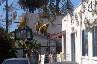 Firefighters removing a huge object that flew onto the roof of a home near a synagogue in Santa Monica on April 7, 2011.