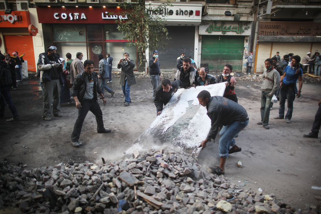 Protesters Gather For Tahrir Square Rally CAIRO, EGYPT - NOVEMBER 23: Protestors clear debris from Mohammed Mahmoud Street after police withdrew on November 23, 2011 in Cairo, Egypt. Thousands of Egyptians are continuing to occupy Tahrir Square after four days of clashes with security forces despite a promise from military leaders to bring forward Presidential elections. (Photo by Peter Macdiarmid/Getty Images)