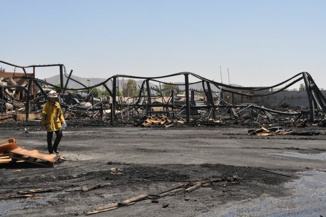 Firefighters sift through the rubble of a wooden pallet company in Fontana on Sunday, May 20, following a huge blaze which completely destroyed the property. The cause remains under investigation.
