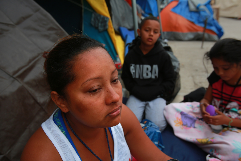 At the El Barretal temporary migrant shelter in Tijuana, Abigail Thompson Maldonado from Honduras, talks about the journey she and her husband and their three children made to reach this spot on Dec. 16, 2018. In the background are Luis Antonio, 9, and Alexandra, 11.