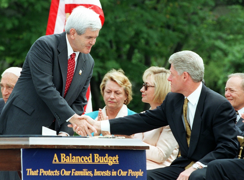 US Speaker of the House Newt Gingrich (L), R-GA, s US Speaker of the House Newt Gingrich (L), R-GA, shakes hands with US President Bill Clinton (R), as First Lady Hillary Clinton (2nd-R) and US Representative Barbara Kennelly (C), D-CT, watches before the President signed the Balanced Budget Agreement on the South Lawn of the White House 05 August in Washington.