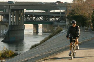 Mercer 15830 A bicyclist rides along a path running along the cement-lined Los Angeles River in Los Angeles.