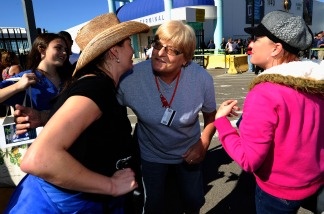 Stranded Carnival Splendor cruise ship passengers Renata Williams (center) and Susanne Christiansen (left) hug after getting off their stranded luxury cruise ship at San Diego Harbor Thursday in San Diego.