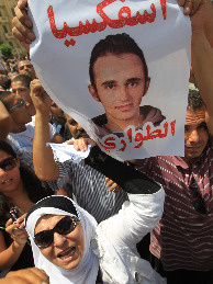 Activists carry a poster with pictures of Khaled Said during an anti-government protest in Cairo, Egypt, on June 20. Said was allegedly beaten to death by two plainclothes policemen on an Alexandria street.