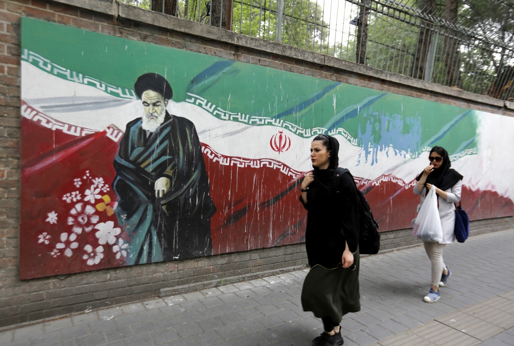 IRAN-US-NUCLEAR-DIPLOMACY An Iranian woman walks past a mural on the wall of the former US embassy in the Iranian capital Tehran on May 8, 2018.