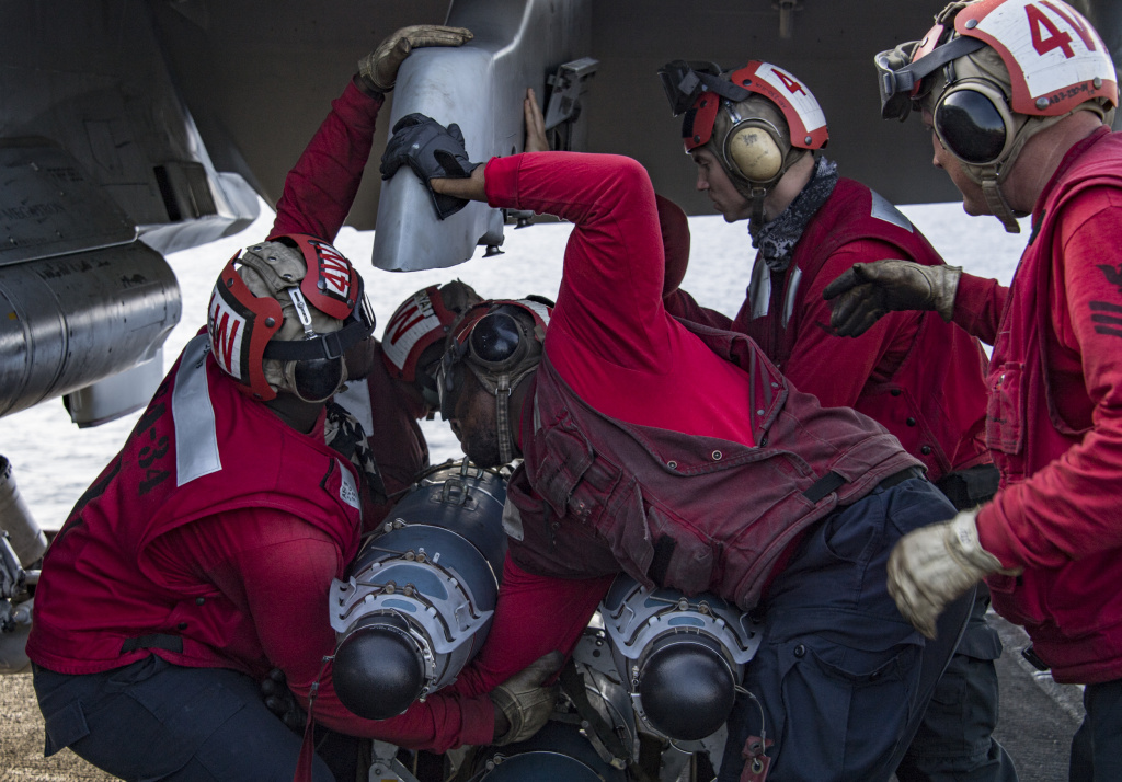 navy nimitz ordnance fighter jet (Feb. 21, 2018) Sailors attach ordnance to an F/A-18C Hornet assigned to the “Blue Blasters” of Strike Fighter Squadron (VFA) 34 on the flight deck of Nimitz-class aircraft carrier USS Carl Vinson (CVN 70).