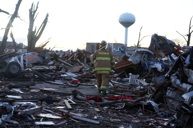A firefighter searches through debris after a tornado struck on November 17, 2013 in Washington, Illinois. Several tornadoes touched down across the Midwest today with at least three people reported dead in Illinois. 