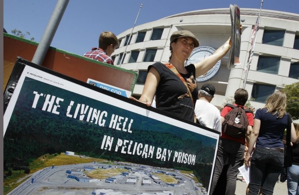 Mercer 19219 A demonstrator holds up a sign during a rally in front of the State Building in San Francisco on July 1, 2011 to support prisoners at Pelican Bay State Prison. Inmates in an isolation unit at Pelican Bay State Prison are on a hunger strike to protest conditions that they describe as inhumane. Advocates say several dozen inmates in the Security Housing Unit declined to eat their morning meal on Friday. The unit holds about a third of the 3,100 inmates at the Northern California prison.