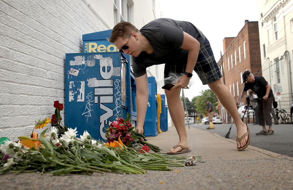 Community Of Charlottesville Mourns, After Violent Outbreak Surrounding Saturday's Alt Right Rally A man places flowers at a makeshift memorial for the victims of the Charlottesville attack where a car plowed into a crowd of demonstrators opposing a white supremacist rally on August 12, 2017.