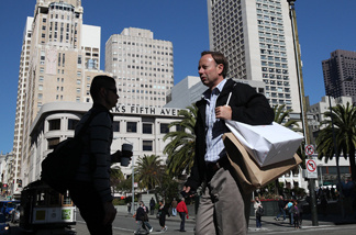 A pedestrian carries shopping bags as he walks through Union Square on Feb. 22, 2011 in San Francisco, Calif. The Conference Board's consumer confidence index reached the highest figure in three years as it rose to 70.4 percent for February, up from 64.8 percent in January.