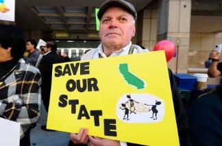 Mercer 13729 Alfredo Sahagun, with Council of Mexican Federations, holds a sign during a rally against proposed budget cuts, with several union and community activist groups representing the disabled, in front of California Gov. Jerry Brown's office on January 10, 2011 in Los Angeles, California.