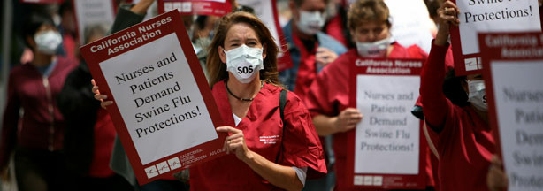 Nurses and hospital workers carry signs and wear masks as they protest outside of the University of California San Francisco medical center August 5, 2009 in San Francisco, California.