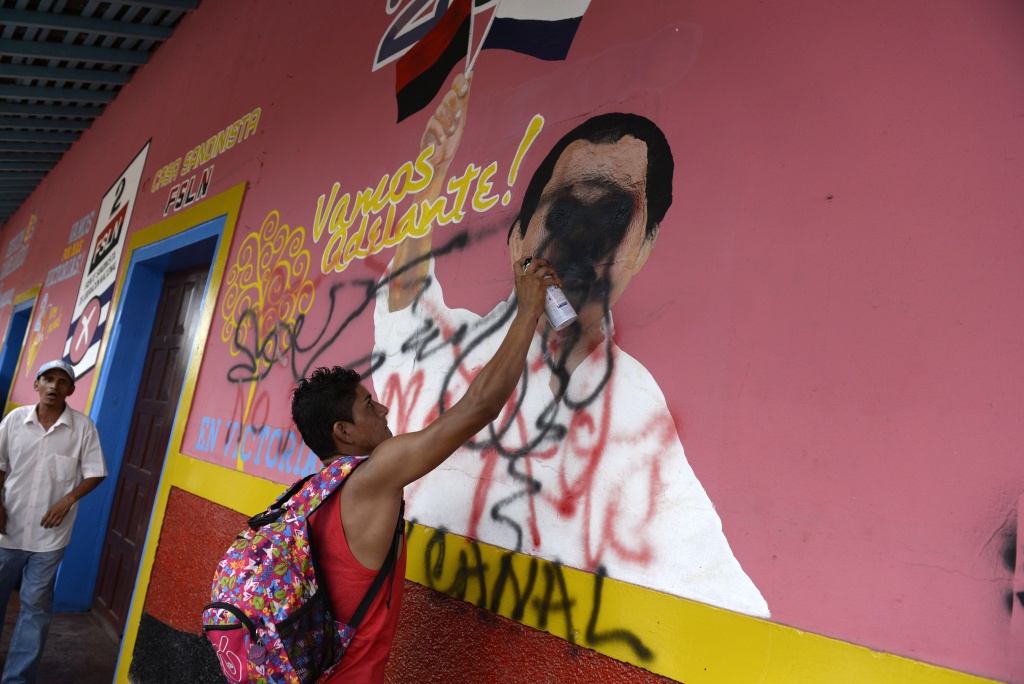 NICARAGUA-CHINA-CANAL-PROTEST A peasant makes a graffiti on a mural of Nicaraguan Presidnet Daniel Ortega during a protest against the construction of an inter-oceanic canal in Juigalpa, Nicaragua on June 13, 2015. Nicaragua and Chinese company HKND Group last year launched construction of an ambitious $50 billion rival to the Panama canal that could handle even larger ships. The canal, which is set to be completed within five years, threatens to displace a small village of the Rama ethnic group and to invade the Indio Maiz reserve, according to environmentalists.