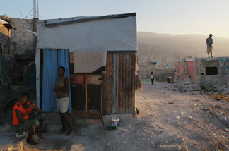 People around their home at approximately the time one year ago a massive earthquake jolted the city on Jan. 12, 2011 in Port-au-Prince, Haiti.