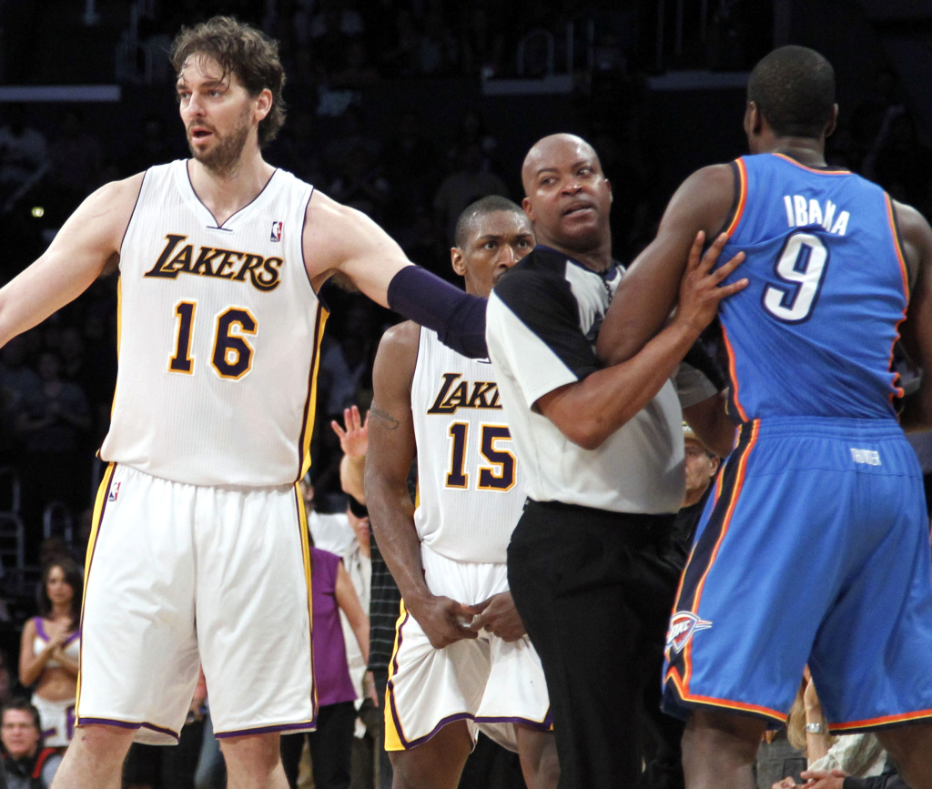 Los Angeles Lakers' Pau Gasol (16), of Spain, stands between an official and Oklahoma City Thunder player after Lakers' Metta World Peace (15) was called for a double flagrant foul and ejected from the game in the first half of an NBA basketball game on Sunday, April 22, 2012 in L.A.