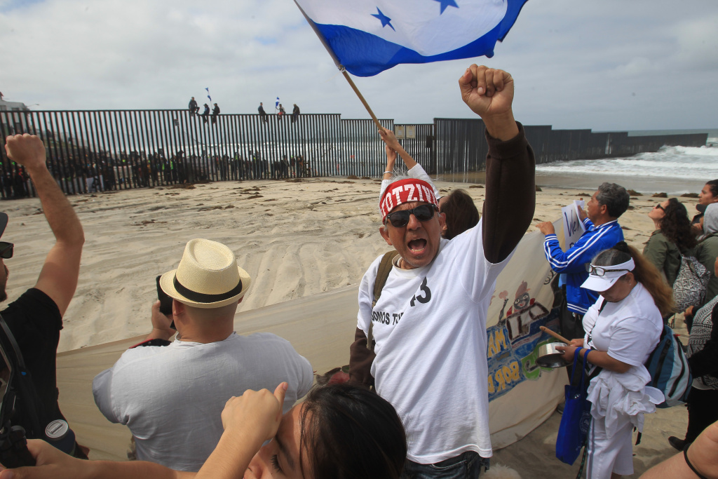 Supporters And Detractors Of Trump's Immigration Policies Demonstrate On Mexican Border Pro-migrant caravan demonstrators, including Manny Aguilar (center) of Los Angeles, rally at the west end of the U.S.-Mexico border as pro-migrant demonstrators climb the border wall from the Mexican side on April 29, 2018 in San Diego, California.