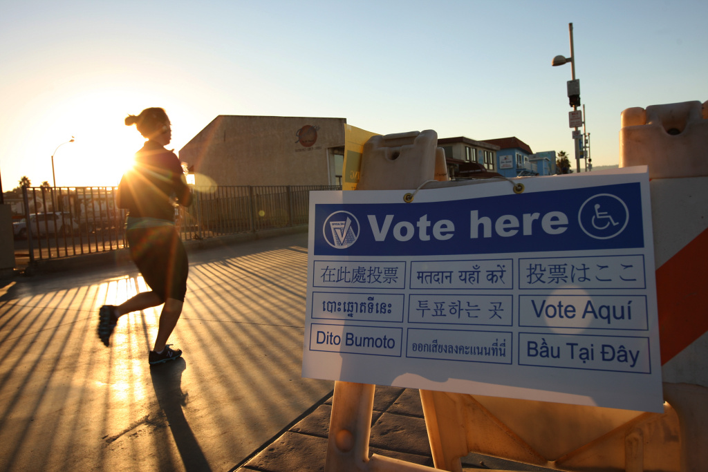 U.S. Citizens Head To The Polls To Vote In Presidential Election A jogger on The Stand, a beachfront walkway, passes a directional sign to a polling place in a Lifeguard Station at sunrise during the U.S. presidential election on November 6, 2012 in the Los Angeles area community of Hermosa Beach, California.