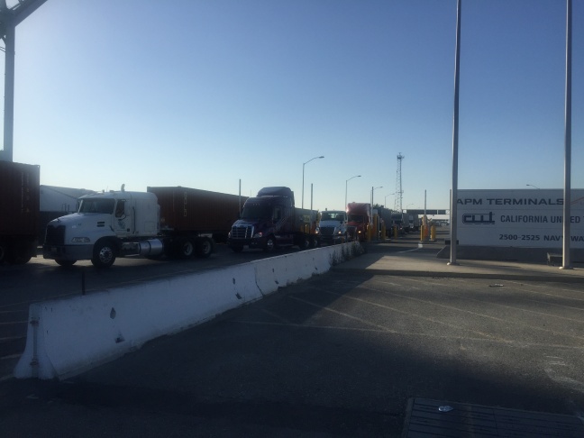 A truck heads into the APM Terminal at the Port of Los Angeles as the sun begins to set