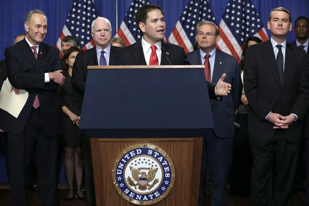 The Group Of Senators Dubbed The U.S. Sen. Marco Rubio (R-FL) speaks as (L-R) Sen. Chuck Schumer (D-NY), Sen. John McCain (R-AZ), Sen. Bob Menendez (D-NJ), and Sen. Michael Bennet (D-CO) listen during a news conference on immigration reform April 18, 2013 on Capitol Hill in Washington, DC. The senators discussed the