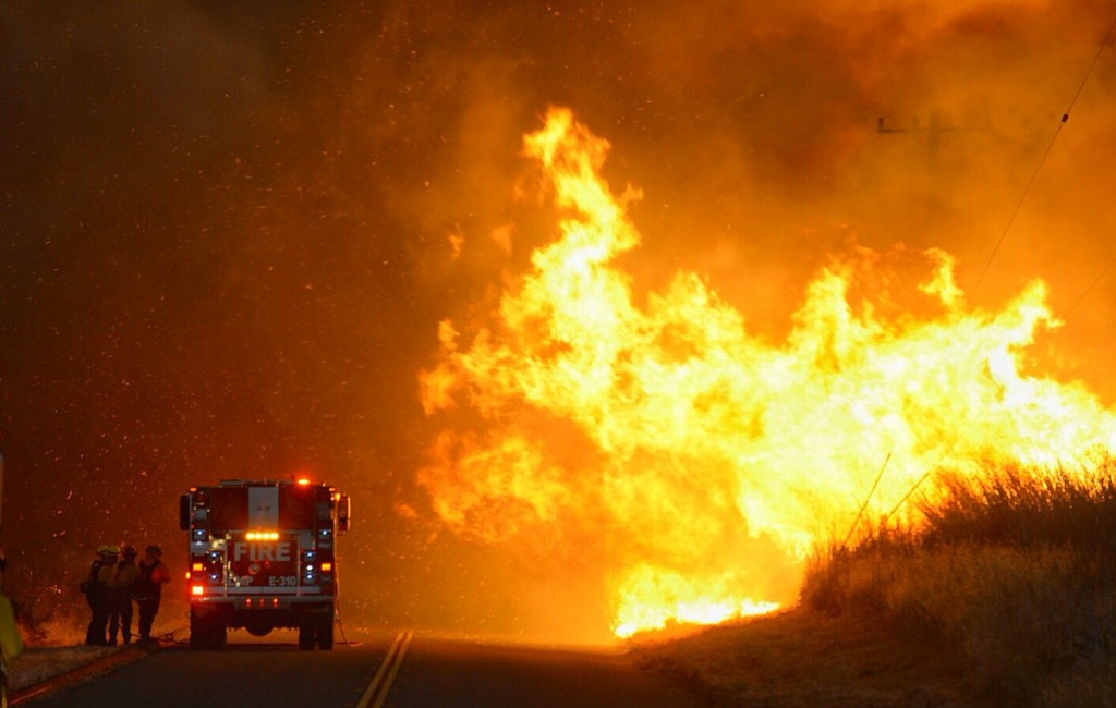 Sherpa Fire Firefighters take shelter behind the engine as flames advance on them along near El Capitan State Beach on Thursday, June 16, 2016.