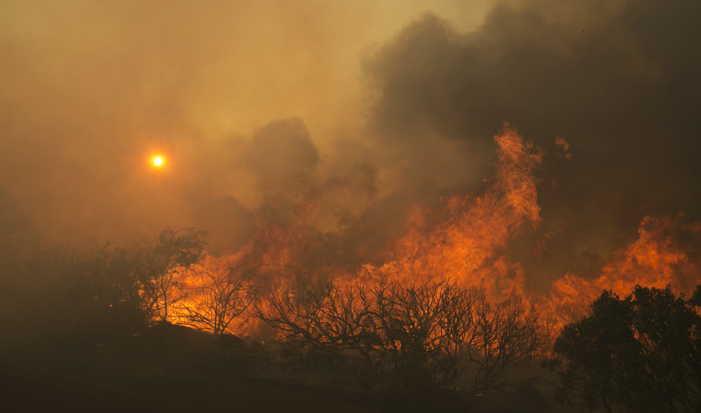 California Wildfires The sun rises as flames from a wildfire burn Monday, Oct. 9, 2017, east of Napa, Calif. The fire is one of several burning across Northern California's wine country.